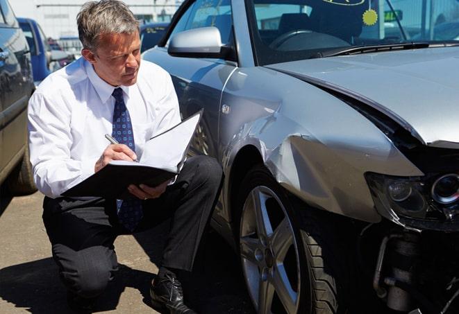 car accident scene with insurance agents assessing the damage